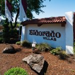 Eldorado Villas in Tigard, OR is a 55 plus manufactured home community with a sign at the entrance and purple and white flags.