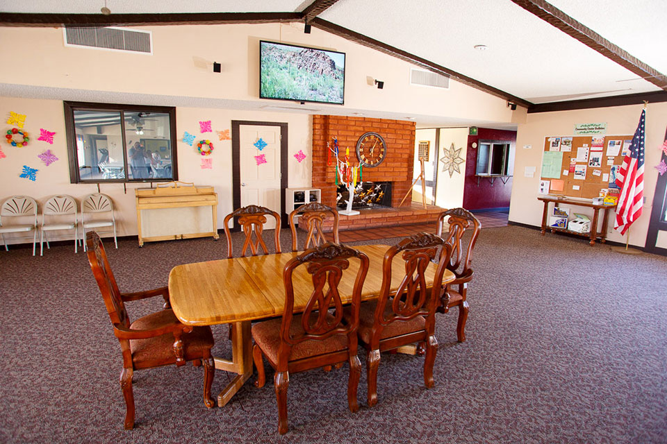 The clubhouse has an organ for playing and announcements on a corkboard of community events. A wood table with chairs is available. A big screen TV is mounted above the fireplace