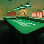 Billiards room offering 4 pool tables, chairs, tables, 2 dart boards, and lighting above each table