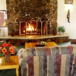 Tranquil community center with stone fireplace surrounded by couches for peaceful relaxation