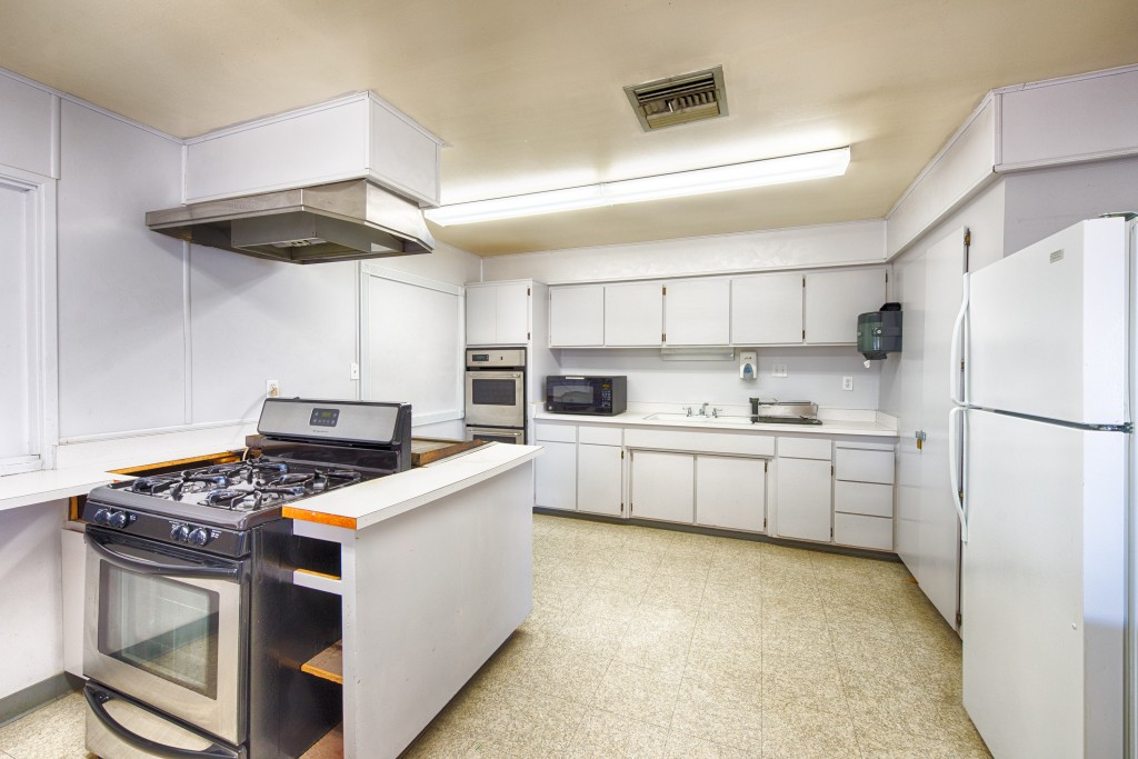 Full size kitchen inside clubhouse with 3 ovens, microwave, fridge and lots of cabinet space.