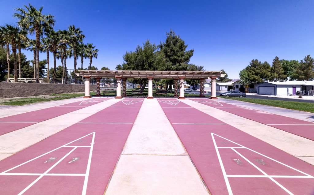 Four shuffleboard courts with covered seating.