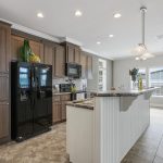 Modern kitchen with brand new fridge, microwave, and oven. Recessed lighting with dark wood cabinets floor to ceiling. Large kitchen island with breakfast nook and tile flooring throughout.