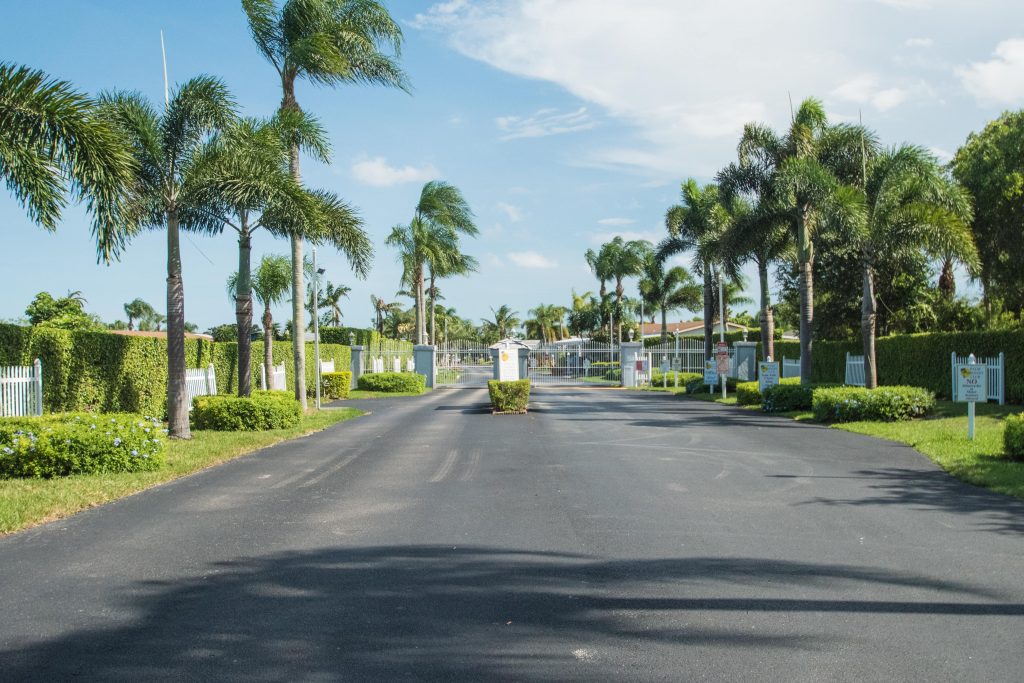 Palm Breezes Club is a gated community landscaped with palm trees down the clean wide paved street.