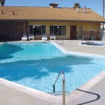 Outdoor heated pool with a large hot tub adjacent to it. Both amenities lie behind the community center, open for residents to host parties with friends and family.