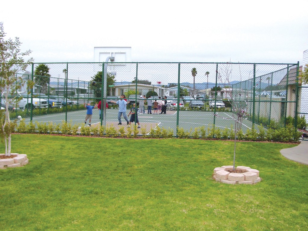 Outdoor basketball court enclosed by gates for residents to enjoy shooting hoops or playing a game of basketball with friends and family.