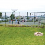 Outdoor basketball court enclosed by gates for residents to enjoy shooting hoops or playing a game of basketball with friends and family.