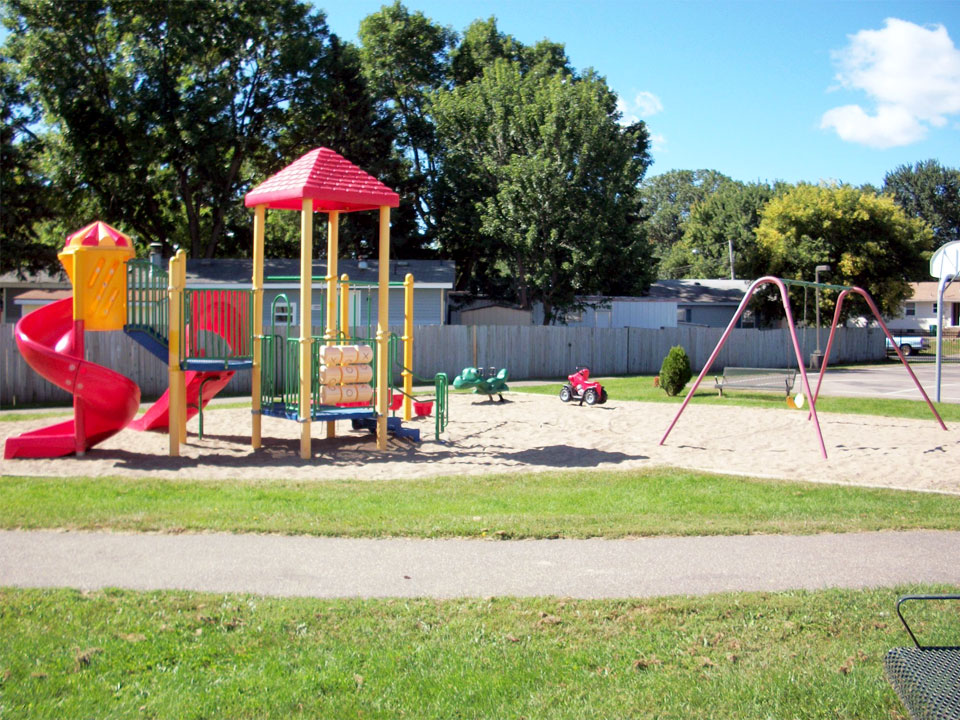 A playground area for the children with swings, slide and jungle gym.
