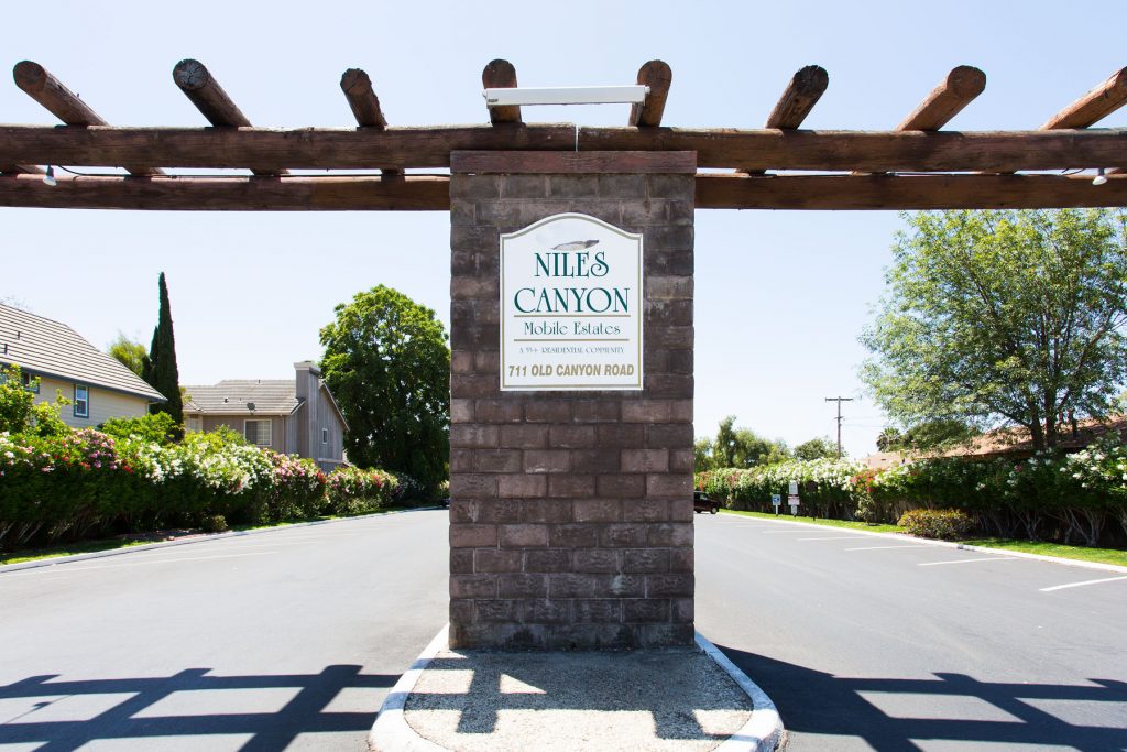 Large front stone divider in the entrance of the community provides the name and address of the community