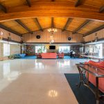 Large, open community center with high, light-wood, vaulted ceilings. Space for residents to lounge on the salmon pink couches or read a book from the novels provided.