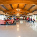 Open concept community center with high vaulted ceilings provides a space for residents to enjoy activities with one another.