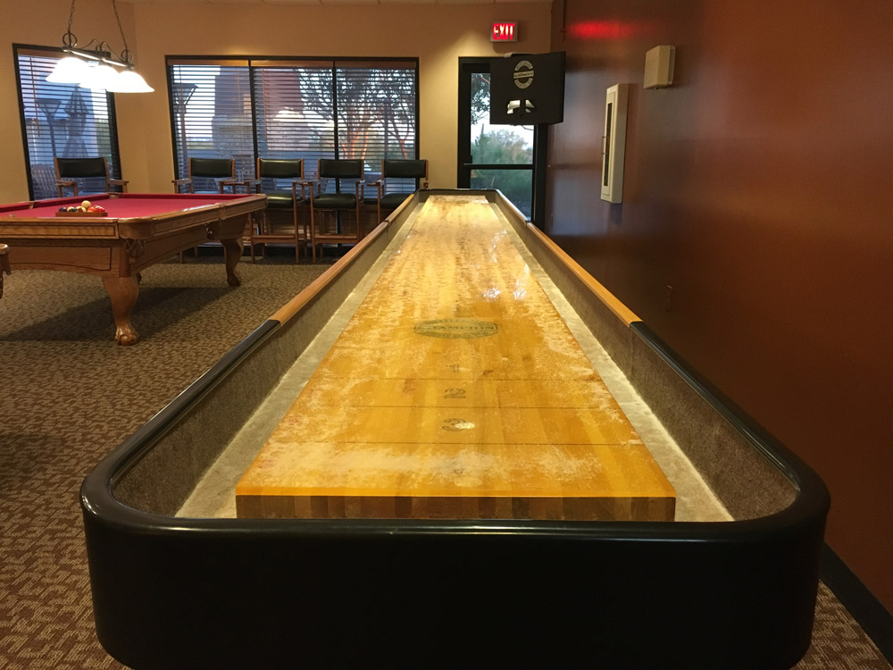 Large game room featuring indoor sawdust shuffleboard and pool table.