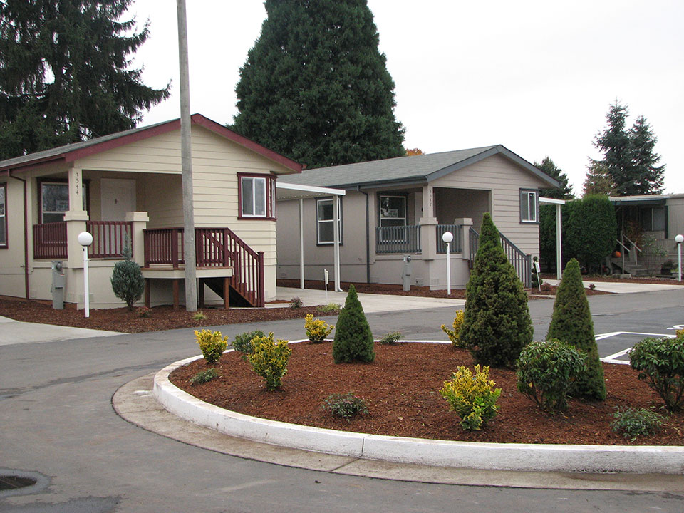 Lakeside Village, an all age manufactured home community with well manicured landscape and lots of tall green trees and shrubs. Well kept homes.