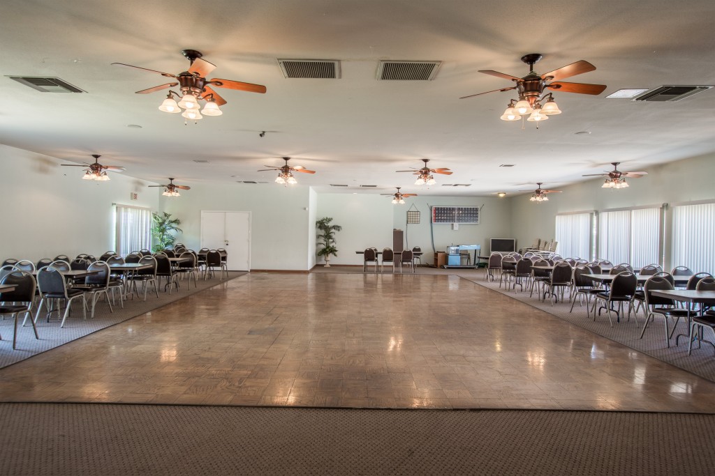 The community room has a dance floor with seating for Bingo times. Nine ceiling fans will help cool off building.