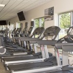 Fully equipped fitness center with treadmills and stationary bikes. TVs are mounted to wall for enjoyment while working out.