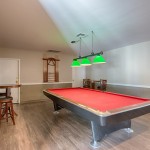 Pool table with bar stool and table seating.