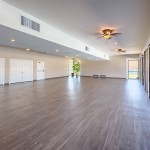 Beautiful hardwood floors and open space in the clubhouse with lots of natural light coming in due to a wall of windows.