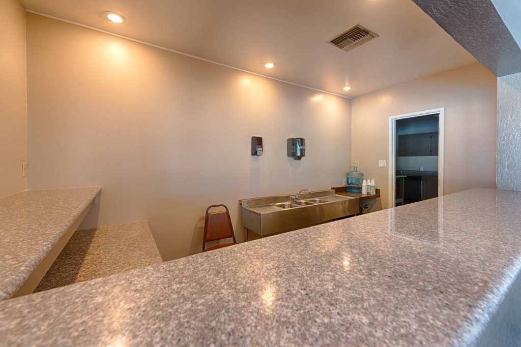 Inside the clubhouse, off the kitchen, is a bar top area with sink to utilize for events.