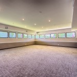 New carpeted meeting room with windows on 2 walls. Recessed lighting.