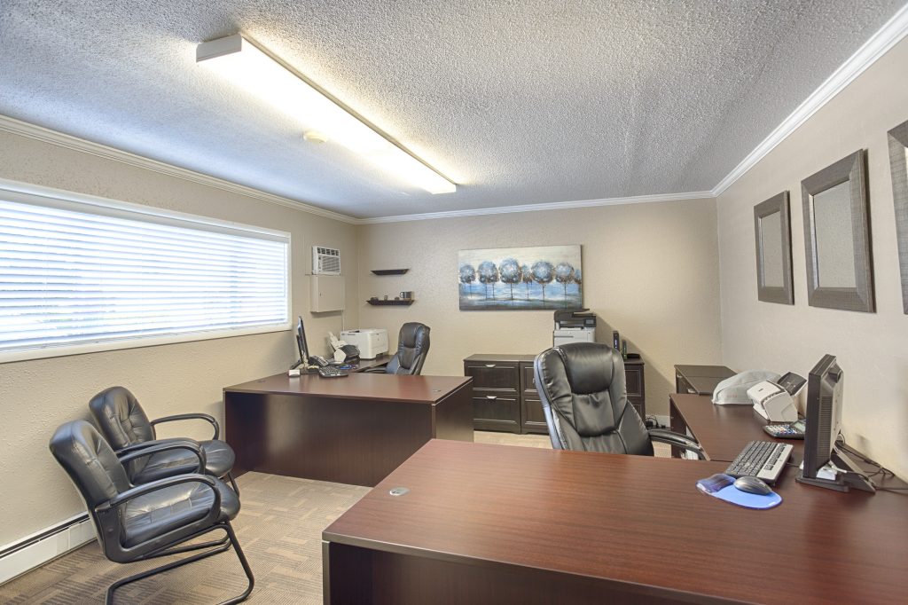 Front office equipped with updated furniture and technology. Neutral colors of brown, beige, and black throughout.