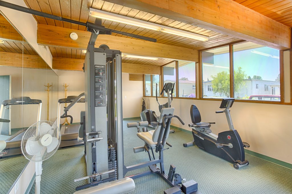 Indoor community gym equipped with a variety of workout equipment for residents use.