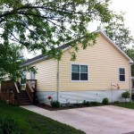 Rolling Hills Estates is an all age family mobile home park community with lush landscaping and tall green trees. Driveway to park the car