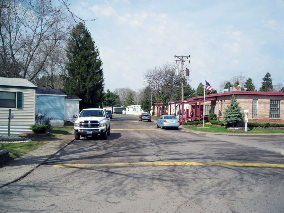 This manufactured home community has wide clean paved streets. Cars can park on the street outside their home.