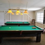 A billiard room with two pool tables.
