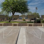 Four shuffleboard courts with scoreboards and seating