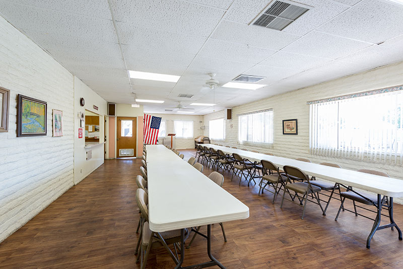 Bingo room equipped with two long tables and fold out chairs for multiple residents to take part in at a time.