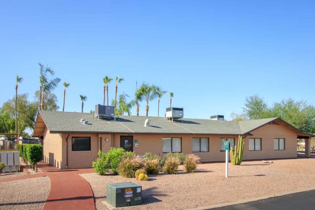 Leasing office of Pueblo Grande, a 55 plus community. Desert feeling with rocks and cactus in the foreground and terracotta coloring on the walkway.